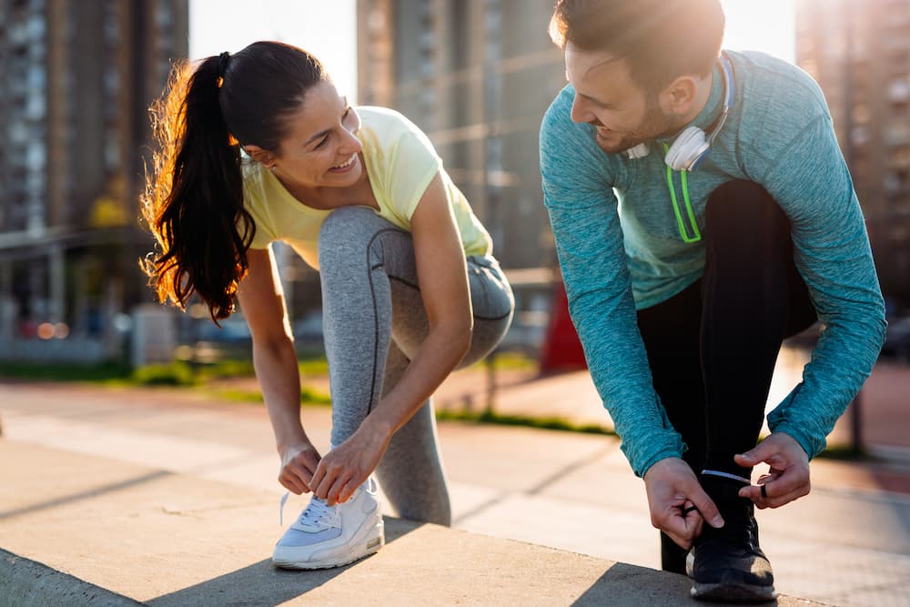 A couple practicing lifestyle medicine habits by preparing for an outdoor workout in San Francisco.
