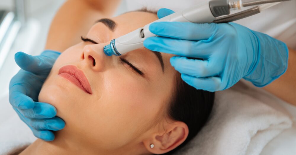 Provider performing a HydraFacial treatment on a relaxed female